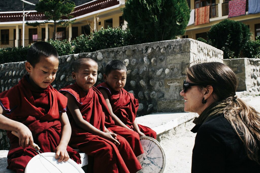 women talking with three young monks